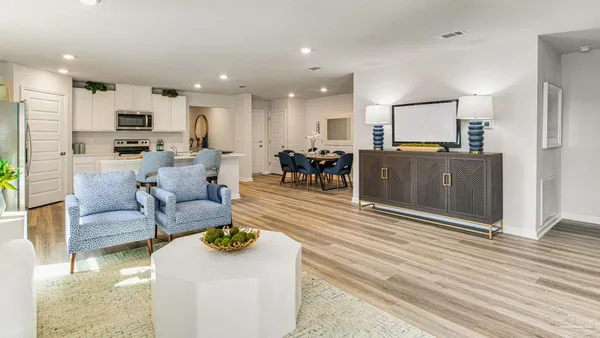 a living room with furniture a large window with kitchen view