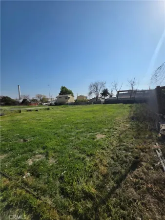 a view of a green field with wooden fence