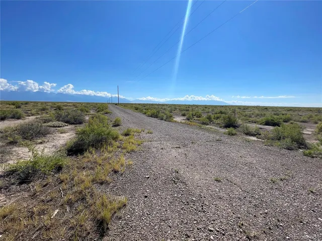 a view of a dry yard with wooden fence