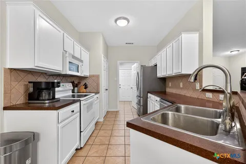 a kitchen with stainless steel appliances granite countertop a sink a stove and cabinets