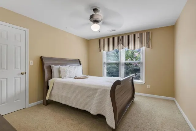 a bedroom with a bed and a large window