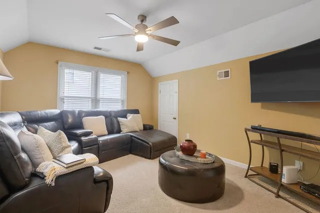 a living room with furniture a flat screen tv and a window