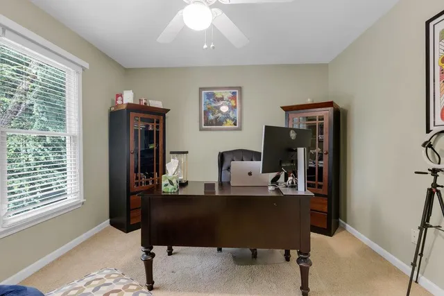 a view of a workspace with furniture and a window