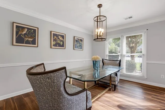 a dining room with furniture a chandelier and wooden floor