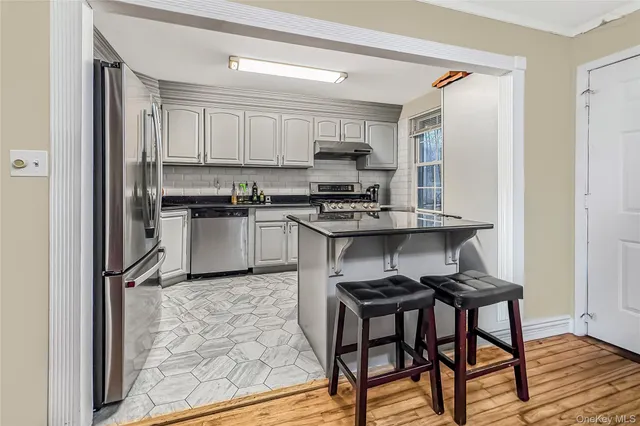 a kitchen with stainless steel appliances granite countertop a stove top oven a sink dishwasher and a refrigerator