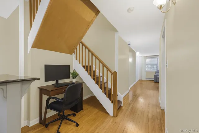 a view of a hallway with workspace and wooden floor