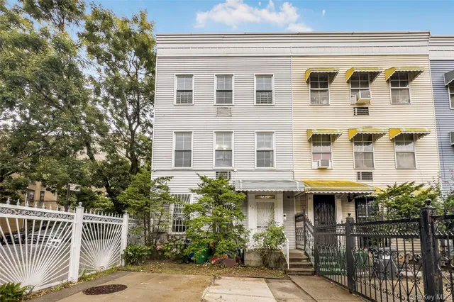 a front view of a house with glass windows and plants