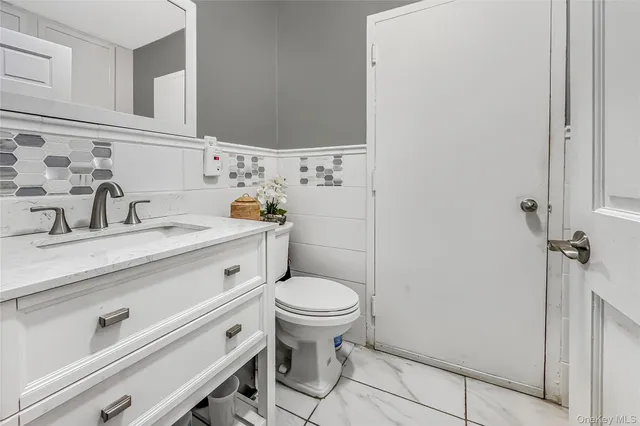 a bathroom with a sink toilet and a mirror