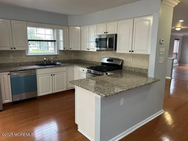 a kitchen with stainless steel appliances granite countertop a stove a sink and a microwave