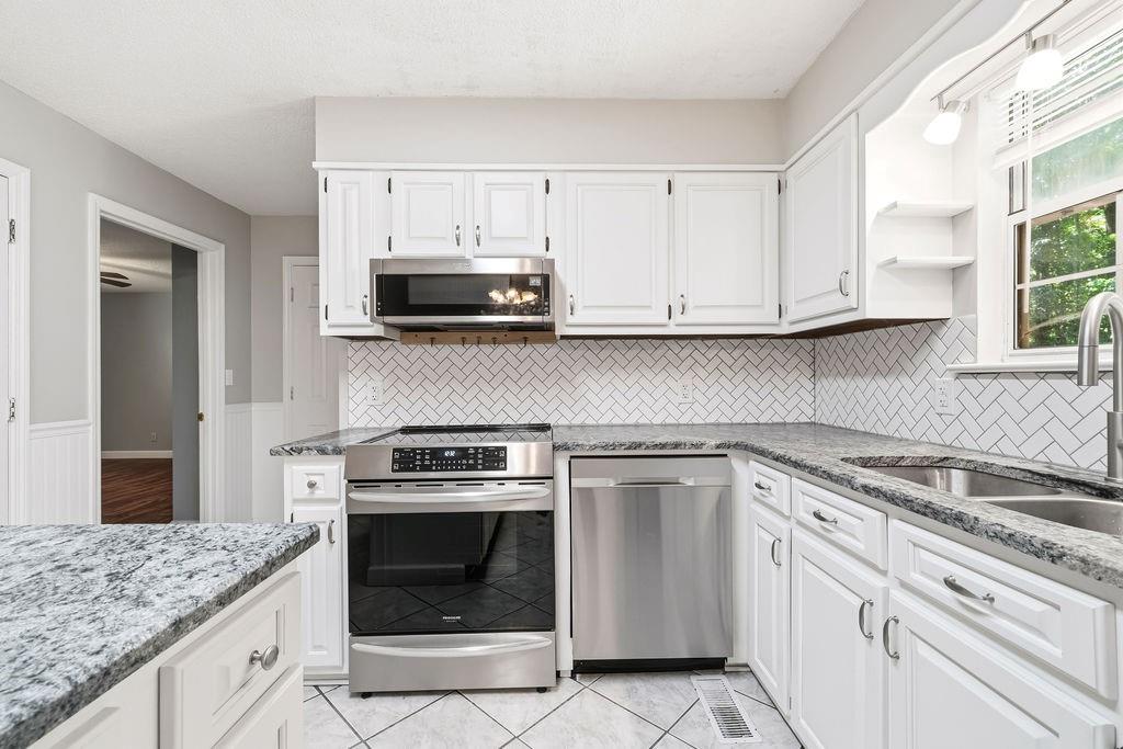 116 Monterey Drive Dalton, GA 30721 - Photo 20 of 39 a kitchen with granite countertop white cabinets and a stove top oven