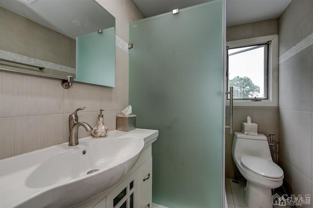 414 Inwood Road Linden, NJ 07036 - Photo 22 of 33 a bathroom with a sink a toilet and a mirror