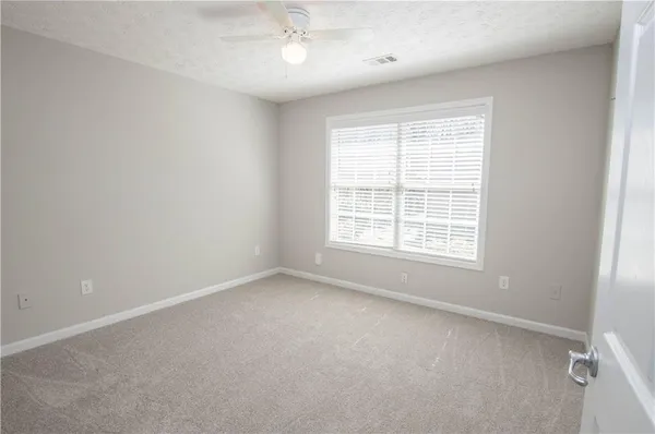 an empty room with a window and a fan