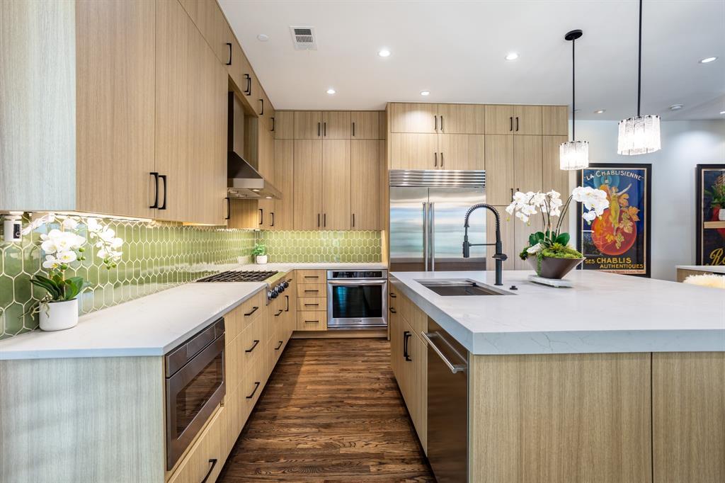 2630 Welborn Street Dallas, TX 75219 - Photo 19 of 40 a kitchen with kitchen island granite countertop a sink a counter top space appliances and cabinets