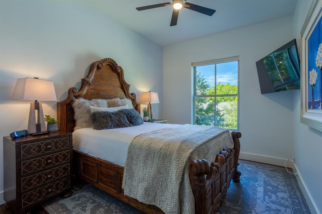 2630 Welborn Street Dallas, TX 75219 - Photo 22 of 40 a bedroom with a bed a chandelier and a window