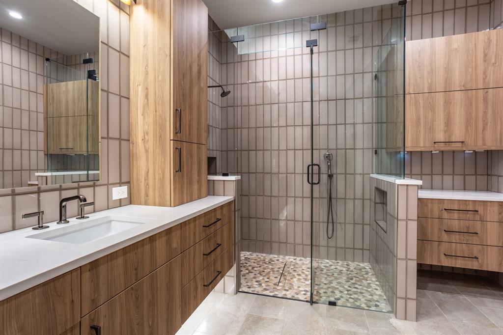 2630 Welborn Street Dallas, TX 75219 - Photo 28 of 40 a bathroom with a sink shower and a mirror