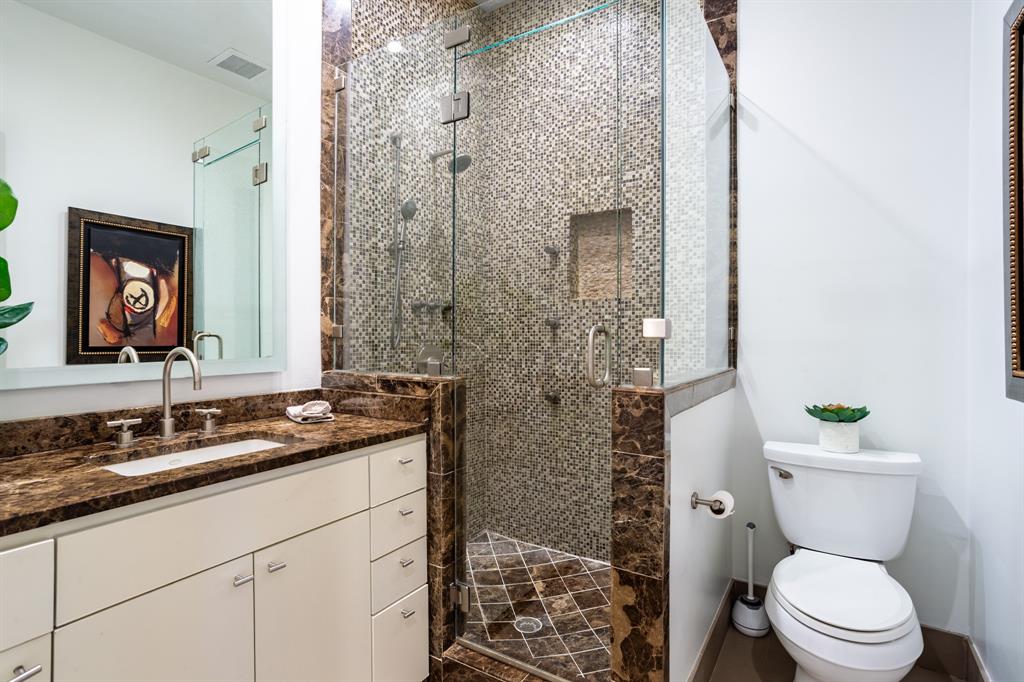 2630 Welborn Street Dallas, TX 75219 - Photo 33 of 40 a bathroom with a granite countertop toilet sink and mirror