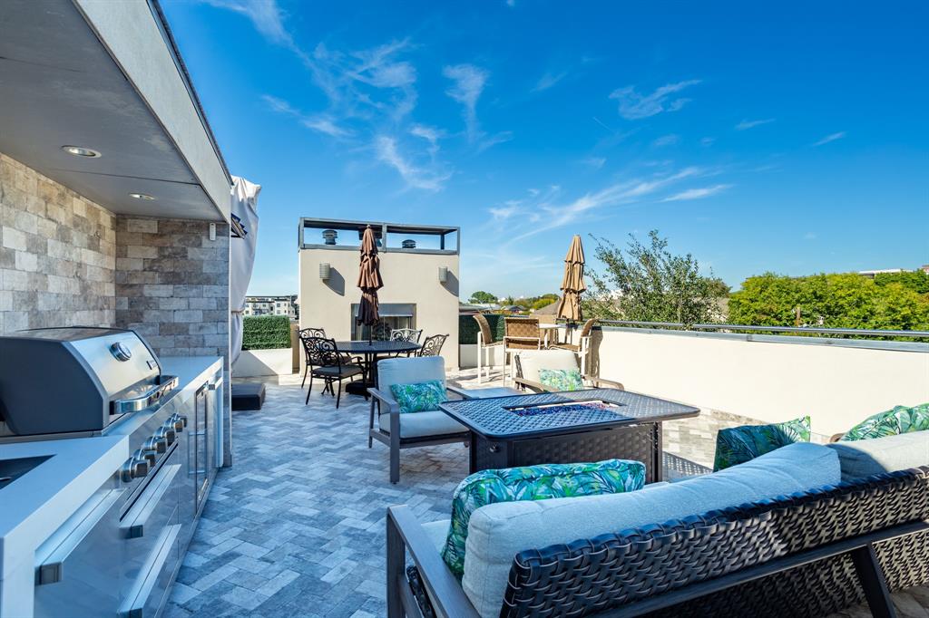 2630 Welborn Street Dallas, TX 75219 - Photo 37 of 40 a view of a patio with couches dining table and chairs with wooden floor and fence