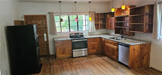 a kitchen with stainless steel appliances granite countertop a stove a sink and a refrigerator