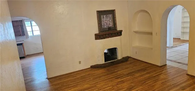 a view of empty room with wooden floor and wall painting