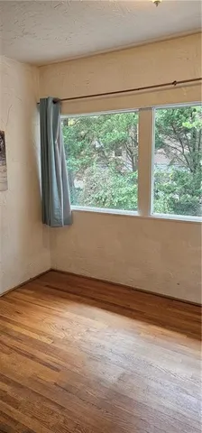 a view of a room with wooden floor and a window