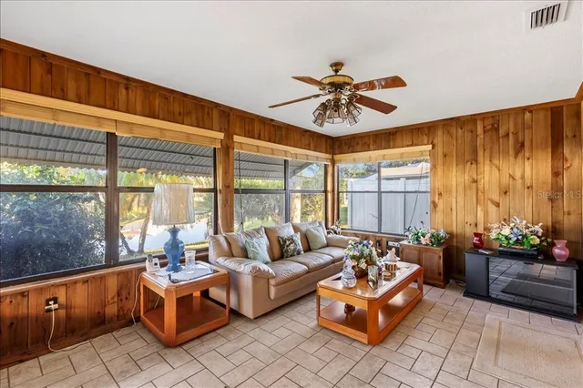 an empty room with windows and fan