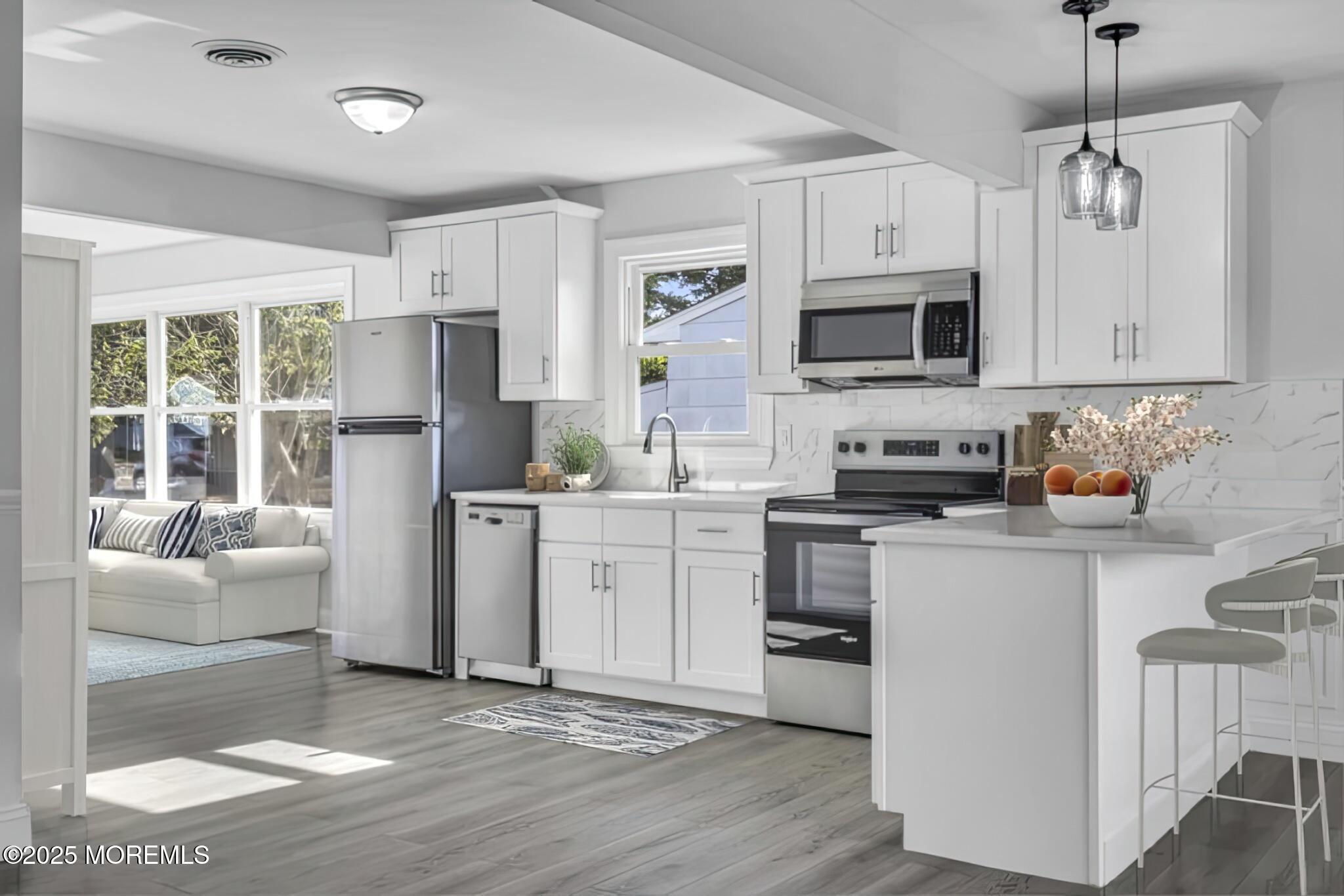 29 Carlisle Road Toms River, NJ 08757 - Photo 11 of 23 a kitchen with stainless steel appliances granite countertop a refrigerator a stove a microwave oven a sink dishwasher and white cabinets with wooden floor