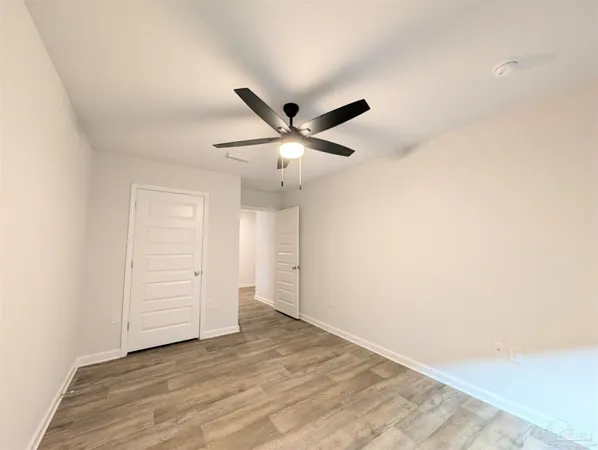 an empty room with closet and ceiling fan