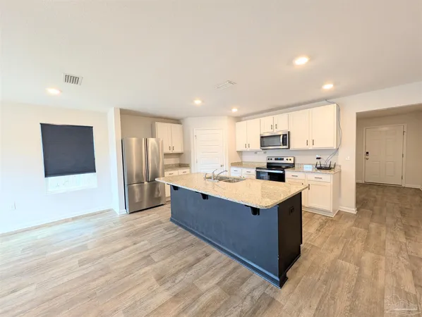 a large kitchen with stainless steel appliances granite countertop a large counter top and a stove top oven