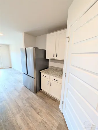 a kitchen with a refrigerator stove and white cabinets