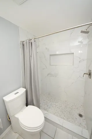 a white toilet sitting next to a bath tub shower