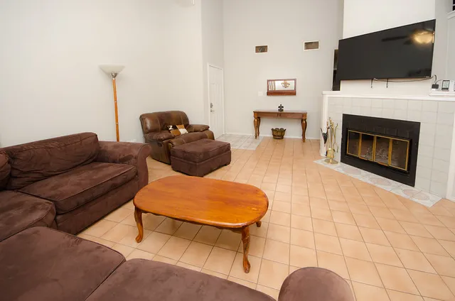 a living room with furniture a flat screen tv and a fireplace