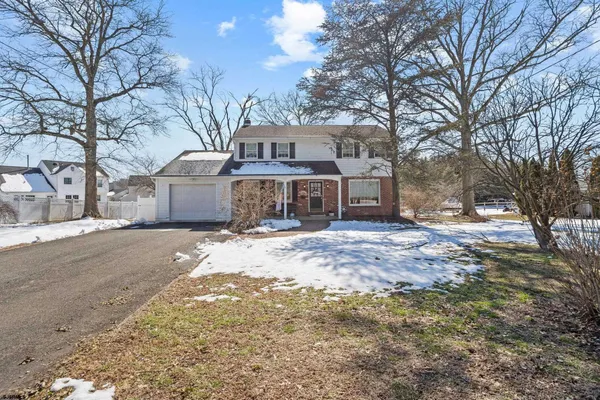 a front view of a house with a yard covered in snow