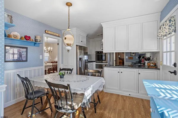 a kitchen with white cabinets and appliances