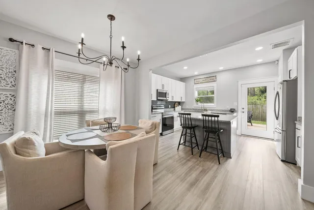 a kitchen with a table chairs stove and cabinets