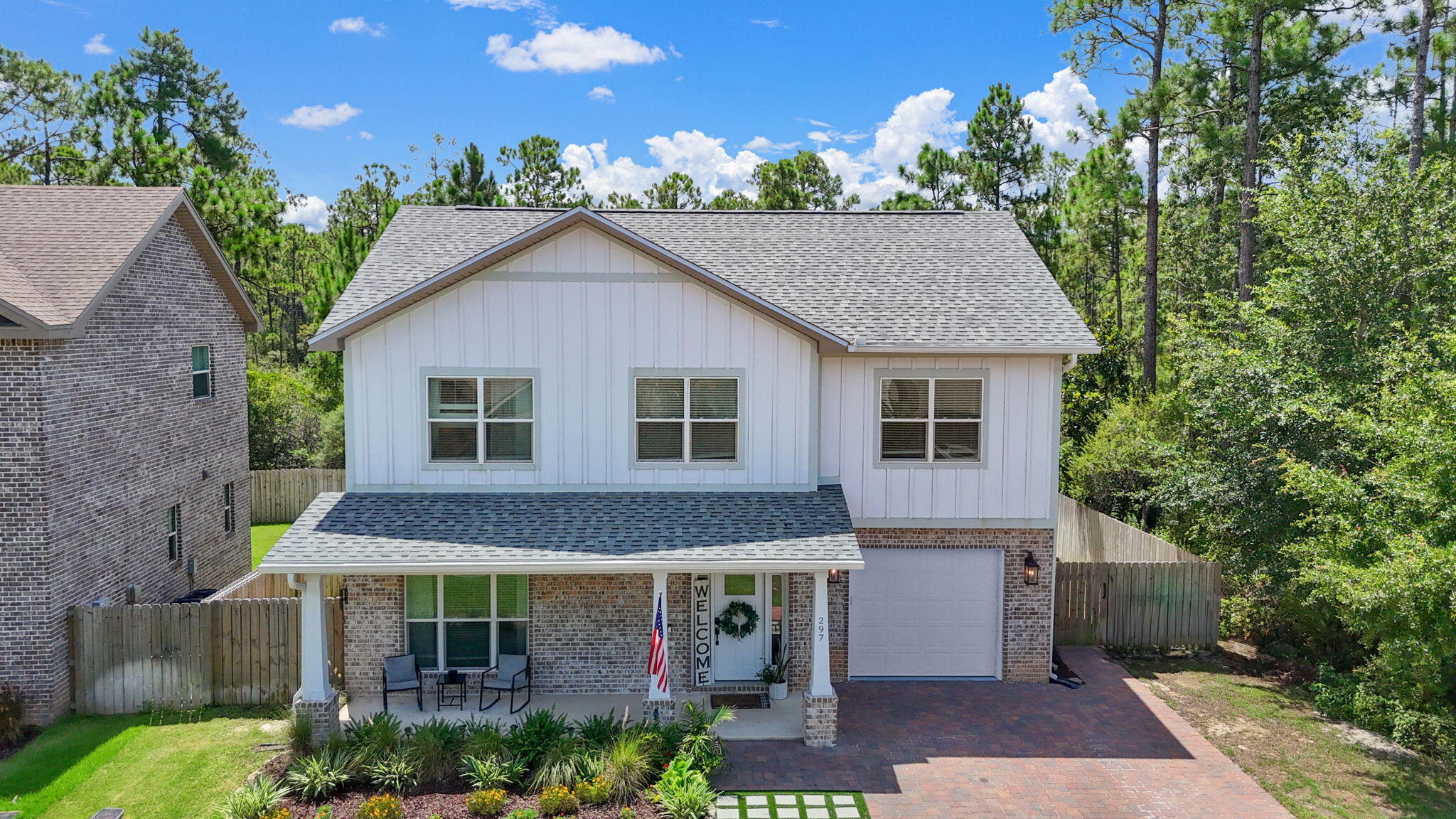 297 Cox Road Santa Rosa Beach, FL 32459 - Photo 2 of 41 a view of a white house with large windows and a small yard