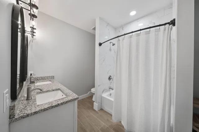 a bathroom with a granite countertop sink and a mirror