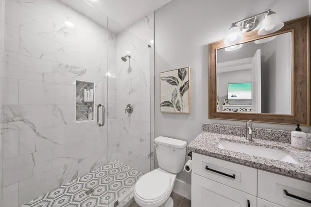 a bathroom with a granite countertop sink toilet and shower