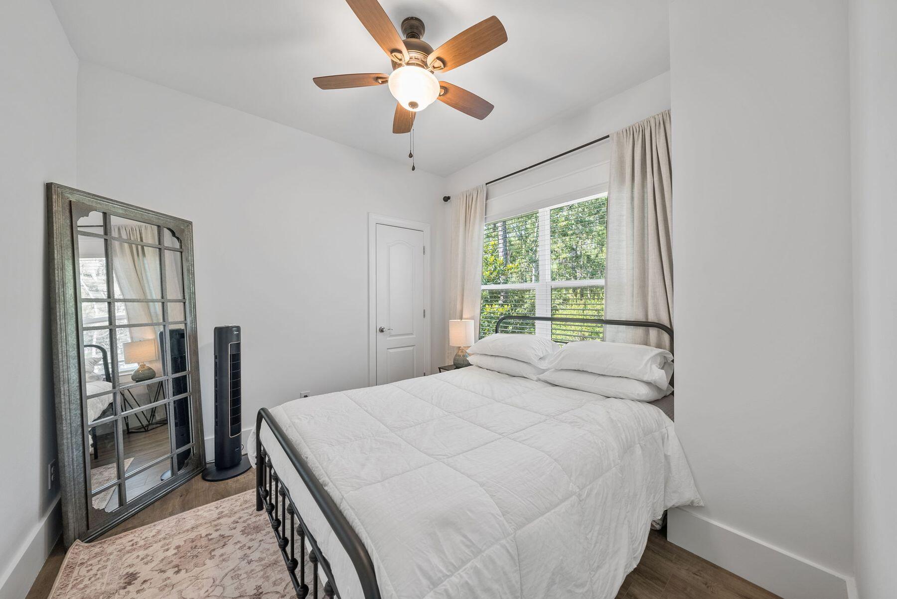 297 Cox Road Santa Rosa Beach, FL 32459 - Photo 32 of 41 a bedroom with a large bed and a chandelier