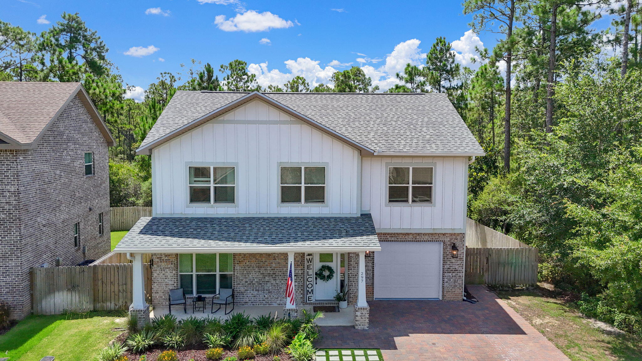 297 Cox Road Santa Rosa Beach, FL 32459 - Photo 41 of 41 a view of a white house with large windows and a small yard
