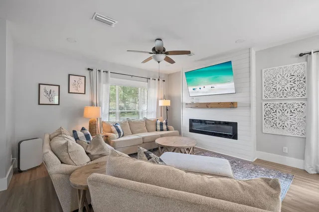 a living room with furniture a fireplace and a flat screen tv