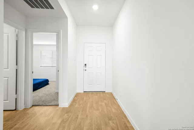 a view of a hallway with wooden floor and closet