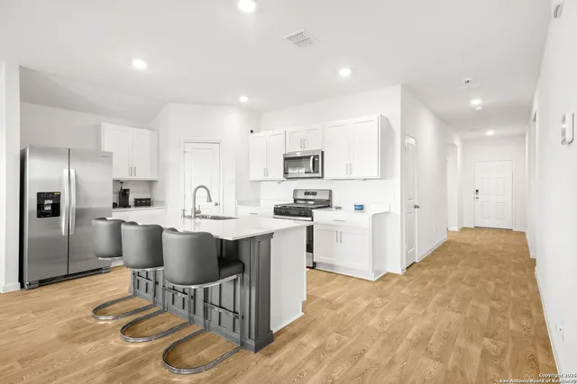 a kitchen with a sink cabinets and refrigerator