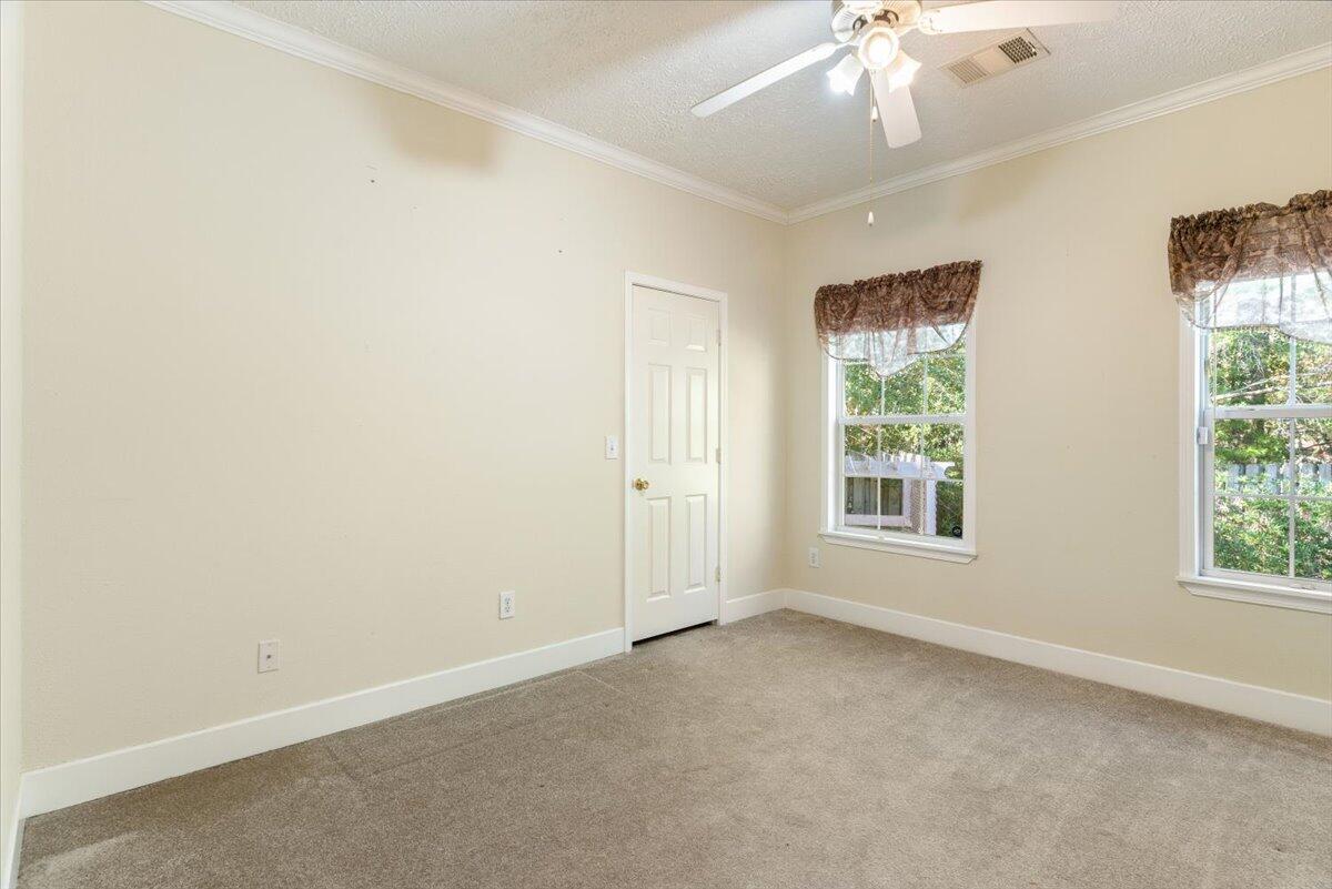 2941 Ferris Drive Navarre, FL 32566 - Photo 18 of 32 an empty room with a chandelier fan and windows