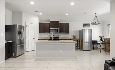 a kitchen with stainless steel appliances a refrigerator and a stove top oven