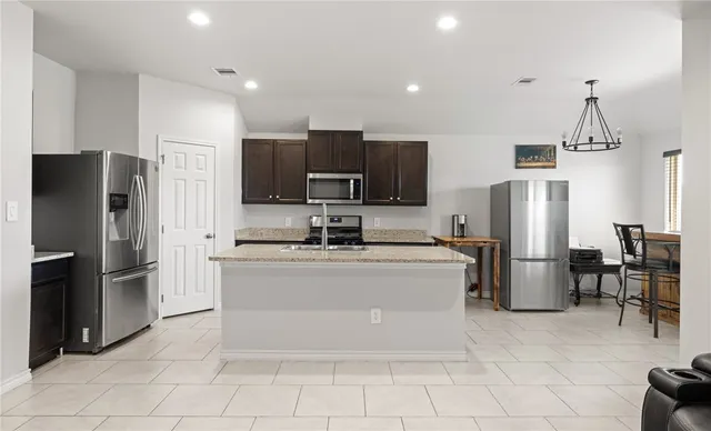 a kitchen with stainless steel appliances a refrigerator and a stove top oven