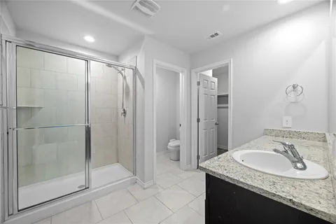 a bathroom with a granite countertop sink a mirror and a shower