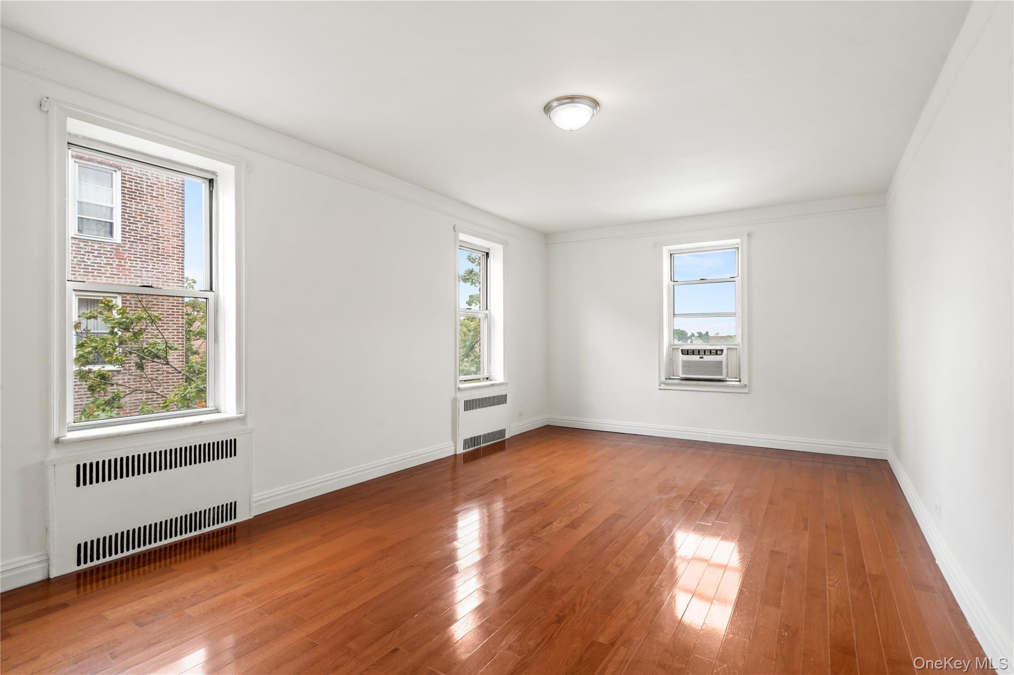 111-39 76th Road, Unit E7 Queens, NY 11375 - Photo 12 of 23 a view of an empty room with wooden floor and a window