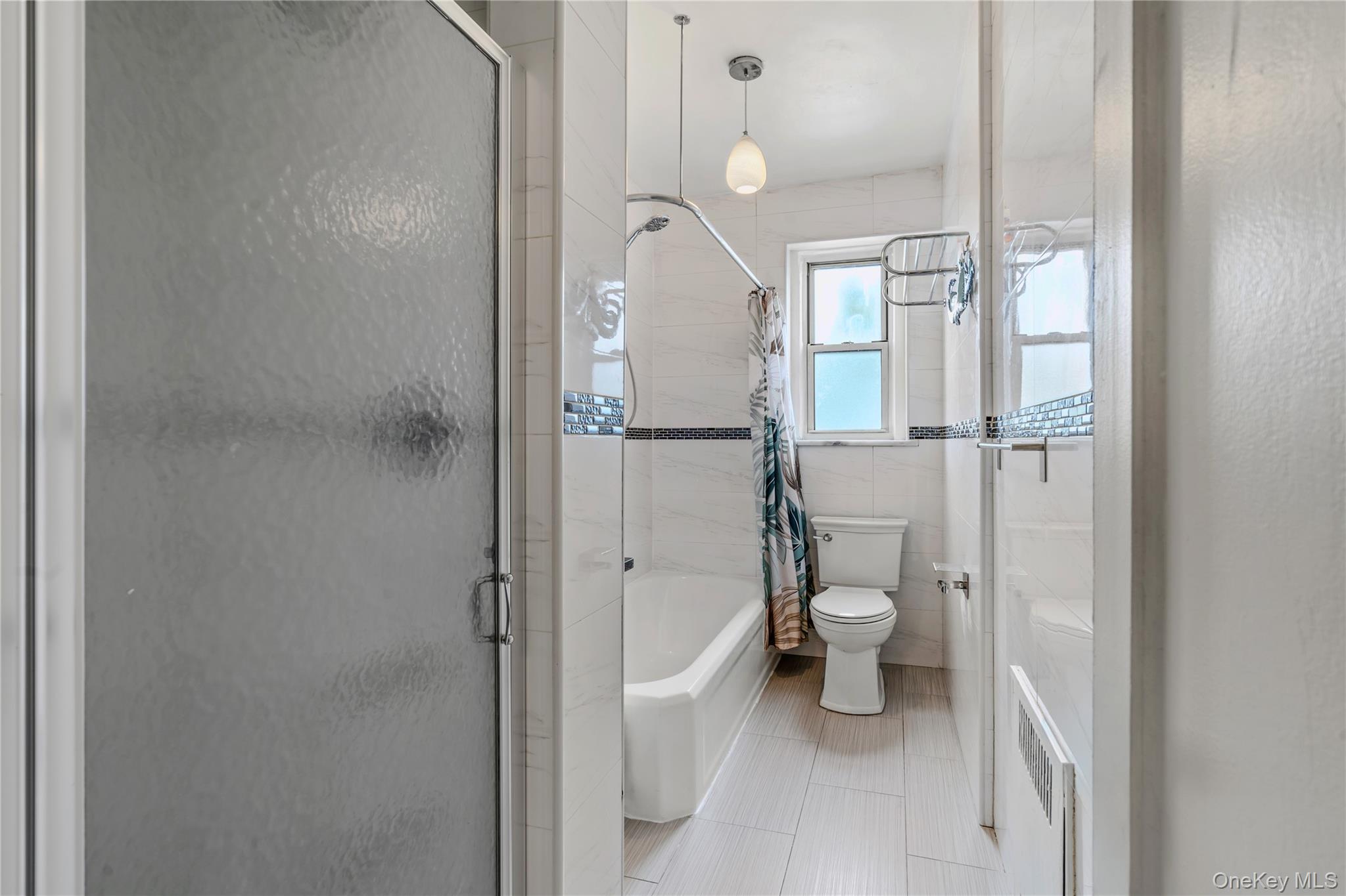 111-39 76th Road, Unit E7 Queens, NY 11375 - Photo 13 of 23 a bathroom with a granite countertop toilet and a shower