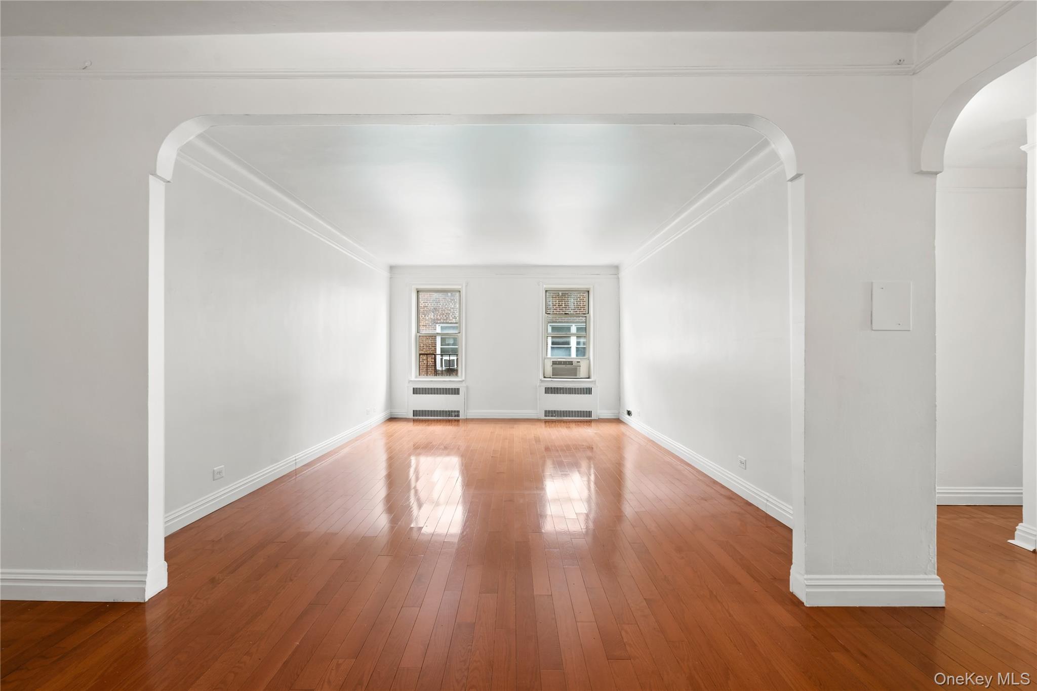 111-39 76th Road, Unit E7 Queens, NY 11375 - Photo 2 of 23 a view of an empty room with wooden floor and windows