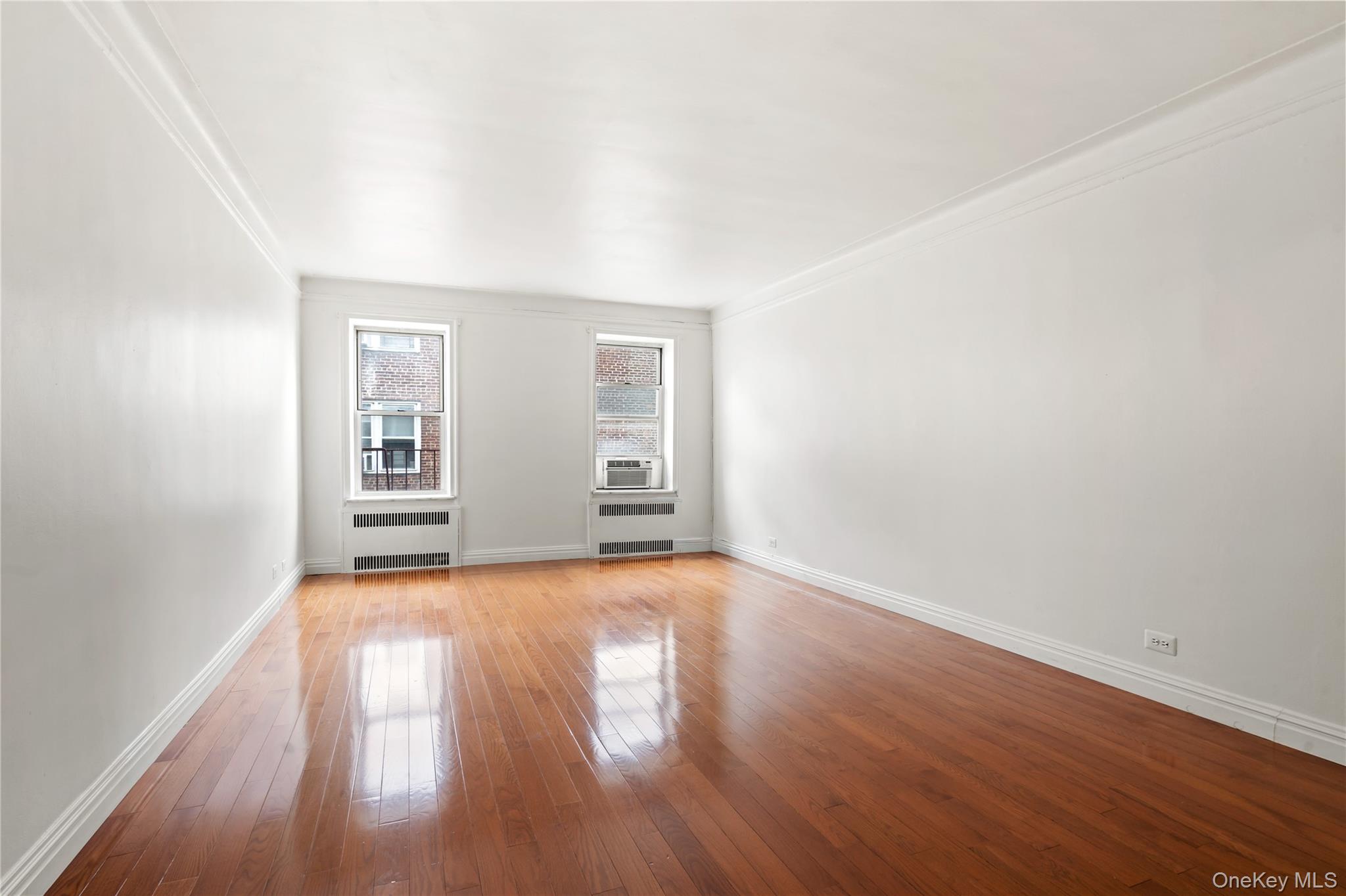 111-39 76th Road, Unit E7 Queens, NY 11375 - Photo 4 of 23 an empty room with wooden floor and windows